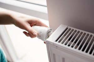 A hand turning up a radiant heating system