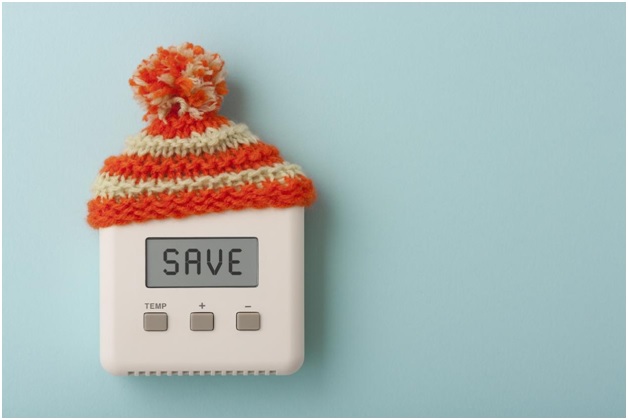 A thermostat wearing a mini beanie with the word 'save'