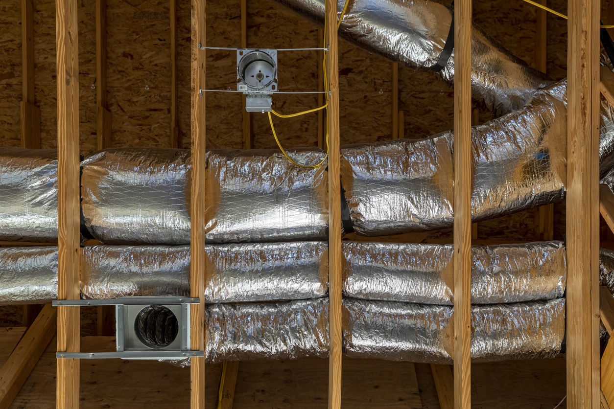 HVAC ductwork inside open new construction wall in residential home