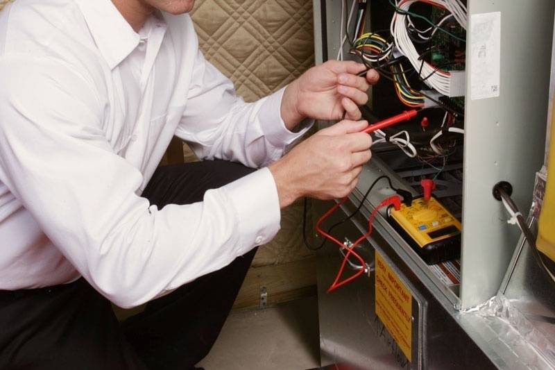 HVAC technician tuning up a residential furnace