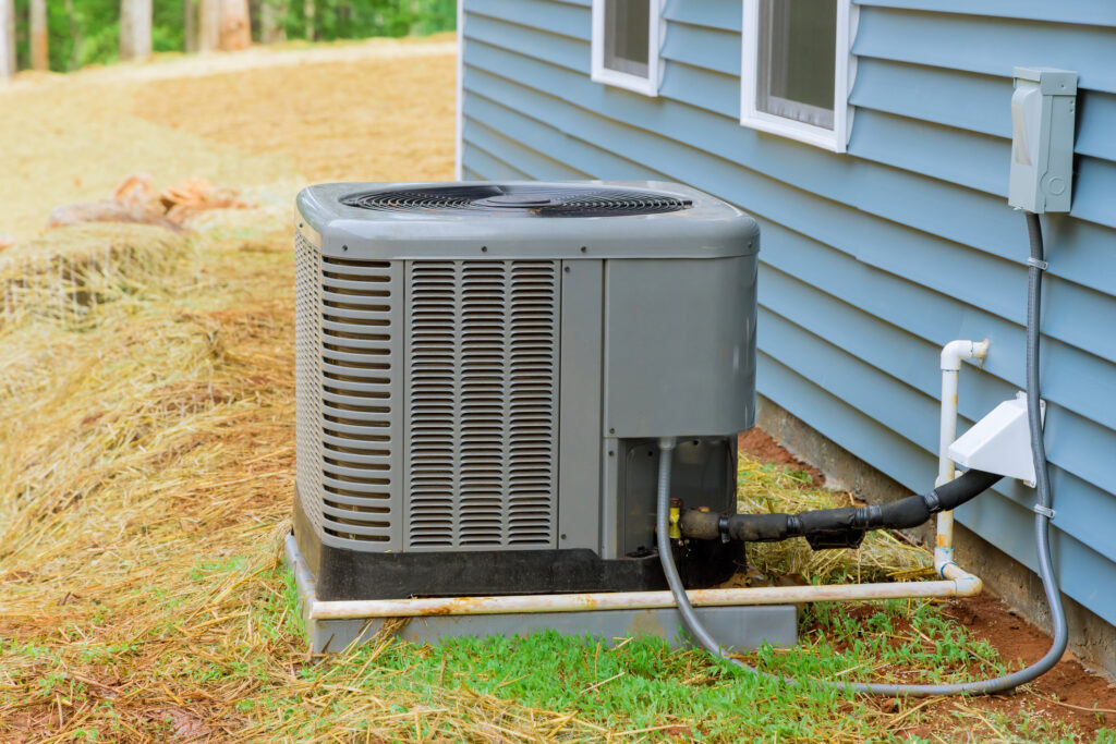 Installation of electric air conditioner residential outside near a new house in Bloomingdale, IL