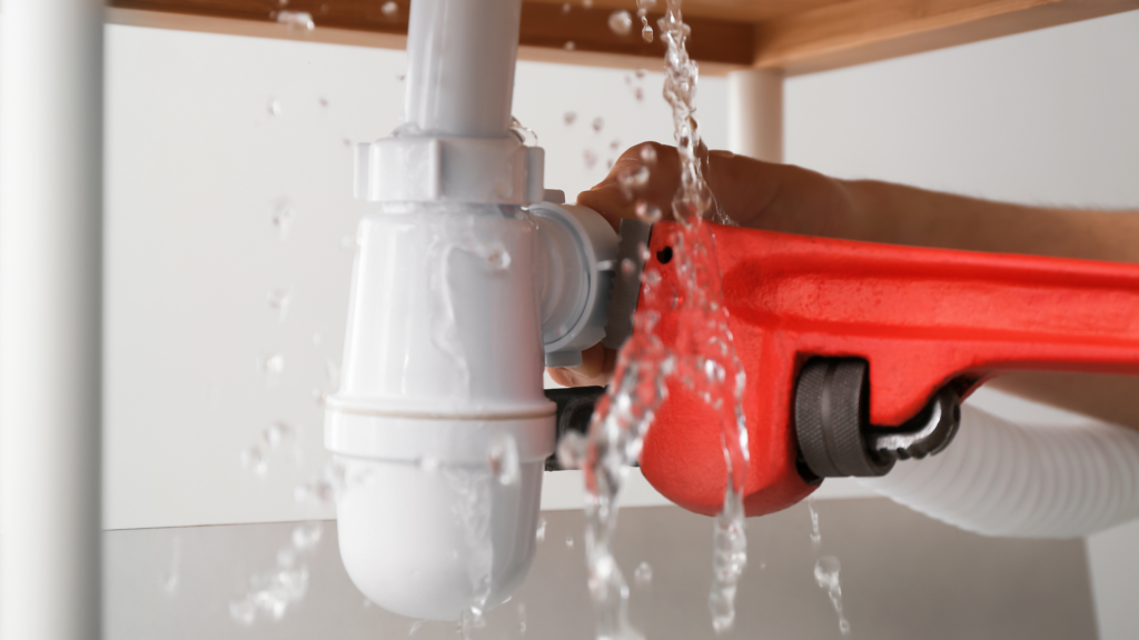 Piping being repaired beneath a sink